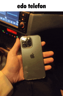 a person is holding an iphone in front of a car radio with the text " edo telefon "