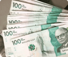 a stack of 100 pesos bills with a man on them