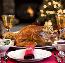 a roasted turkey is on a plate with a red napkin