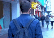 a man with a backpack walking down a street
