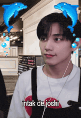 a man wearing headphones and a shirt that says intak de jochi looks at the camera