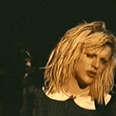 a close up of a woman 's face with a microphone in the background