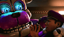 a man in a purple hat sits next to a purple stuffed animal