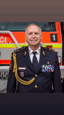 a man in a military uniform stands in front of a fire truck with the number 1 on the side