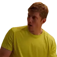 a man in a yellow shirt looks surprised with his mouth open