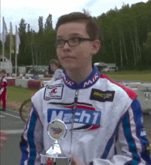 a young boy holding a trophy that says machi