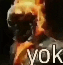 a close up of a person 's face with fire coming out of it and the words yok .