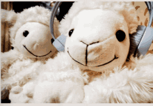 two white stuffed sheep wearing headphones and smiling