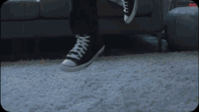 a person 's feet are shown in black and white converse shoes