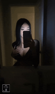 a woman taking a selfie in front of a mirror