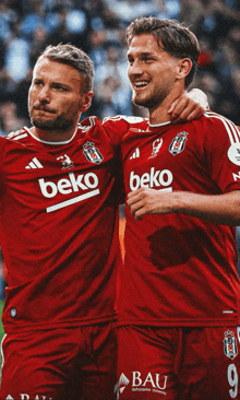 two soccer players wearing red jerseys that say beko