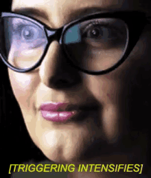 a close up of a woman wearing glasses with the words triggering intensifies written below her