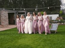 a bride and her bridesmaids are posing for a picture in front of a chair that says ' mercedes ' on it