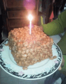 a birthday cake made out of baked beans with a candle