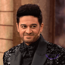 a man wearing a black sequined jacket and a bow tie with the words one happy instant on the bottom