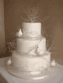 a white wedding cake with white doves and pearls on it