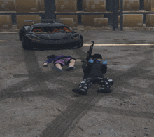 a man with a gun laying on the ground in front of a black car