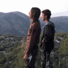 two people standing on top of a hill with one wearing a fox pants