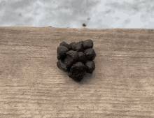 a bunch of black stones are sitting on a wooden surface