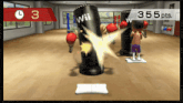 a wii game shows a person hitting a punching bag with 355 pts
