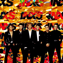 a group of men are standing in front of a colorful background with the word xs on it