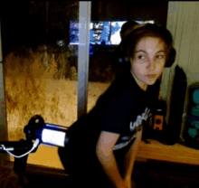 a woman wearing headphones and a black shirt that says ' u.n.i. ' on it