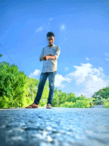 a young man standing on the side of a road