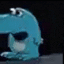 a blue dinosaur with white spots on its head is sitting on a rock .