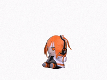 a stuffed toy of a girl with orange hair is laying down on a white surface