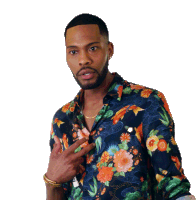 a man wearing a floral shirt is giving a peace sign with his hand