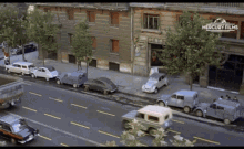 a row of cars are parked on the side of a street in front of a building that says mercury film