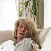 a woman with blonde hair is sitting on a couch