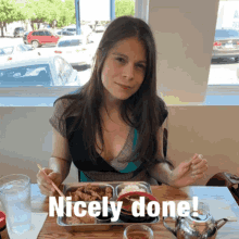 a woman is sitting at a table with a plate of food and the words nicely done on the table