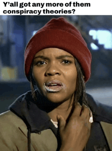 a woman wearing a red beanie and a hoodie is asking if she has any more of them conspiracy theories