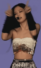a woman in a crop top is dancing on a stage with a microphone .
