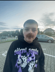 a man with a fake mustache wearing a silent souls hoodie