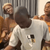 a man in a white t-shirt is dancing in a room with other people .