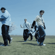 a group of young men are dancing in a field with one wearing a shirt that says ' nz ' on it