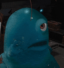 a blue cartoon character with red eyes is looking at something