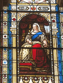 a stained glass window shows a woman holding a sword