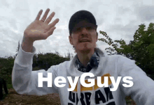 a man wearing a hat and a sweatshirt that says hey guys