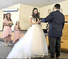 a bride and groom are getting married in a church and the bride is wearing a white dress