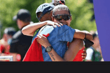 a woman with a tattoo on her arm that says " i love you " is hugging a man in a blue shirt