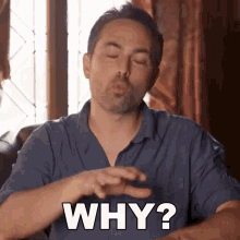 a man in a blue shirt is making a face and saying why