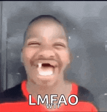 a young boy with a missing tooth is making a funny face and laughing .
