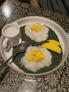 a plate of food with rice and mango on a leaf