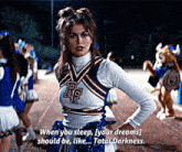 a cheerleader with the letter rf on her top is standing on a track with her hands on her hips .