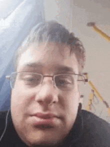 a young man wearing glasses is taking a selfie .