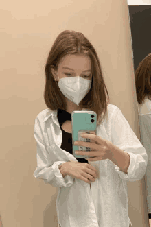 a girl wearing a face mask takes a selfie