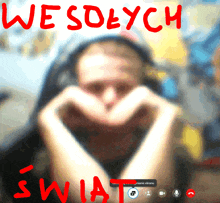 a blurry picture of a man making a heart shape with his hands and the words wesolych swia